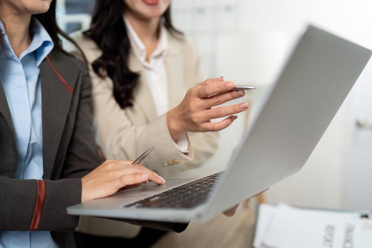 Dialogue commercial efficace lors d’un business meeting avec laptop pour maximiser l’impact lors du sourcing d’un appel d’offre.